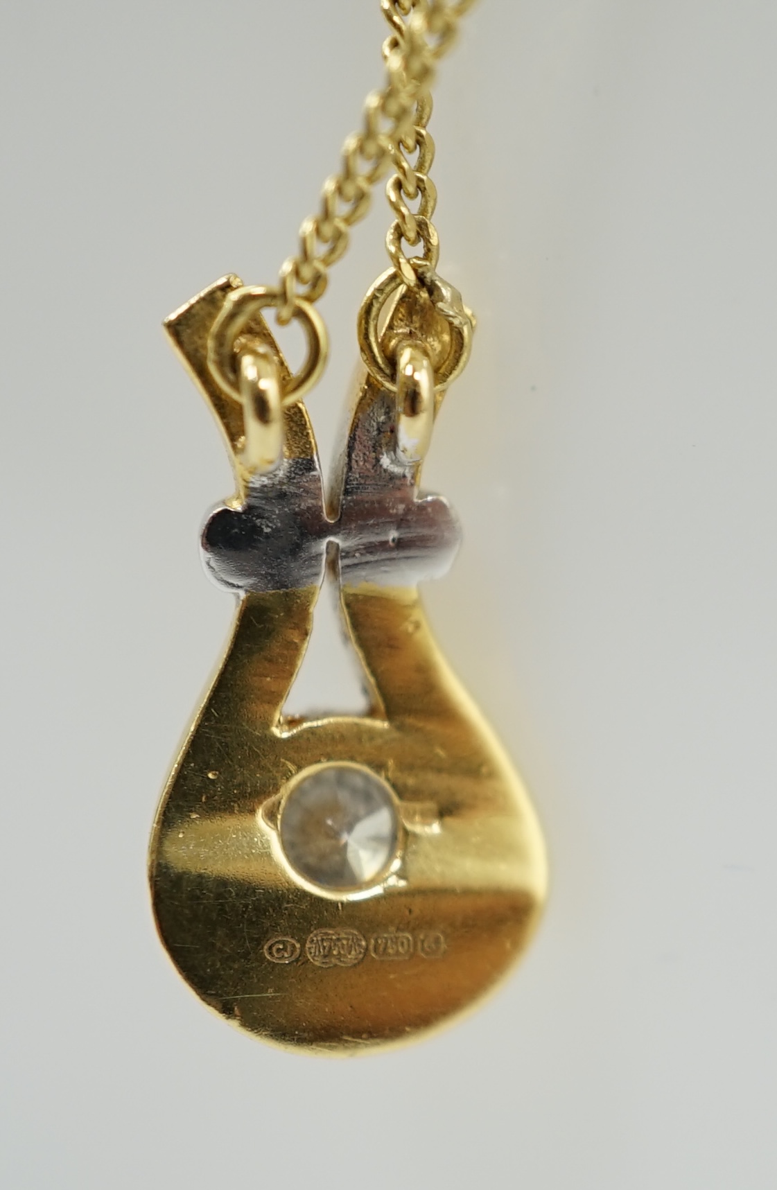 A modern 18ct gold and solitaire diamond set pendant, on an 18ct gold fine link chain